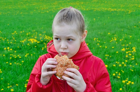 Frightened beautuful girl eating hamburger 