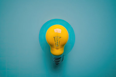 flat lay photo of yellow bulb on turquoise blue background. Illustration Generative AIの素材