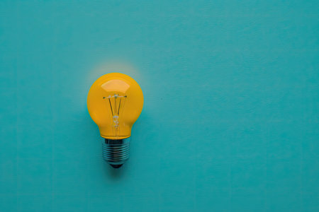 flat lay photo of yellow bulb on turquoise blue background. Illustration Generative AIの素材