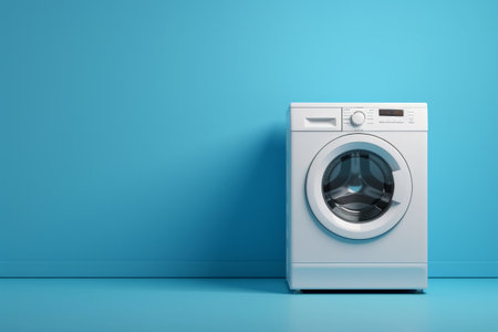 White washing machine stands isolated on blue background.の素材