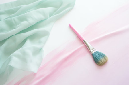 a pink brush, pencil, brushes and watercolors laying on a white surface.の素材