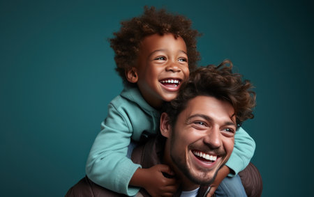 young african american man and small boy enjoying themselves on the shoulders.の素材