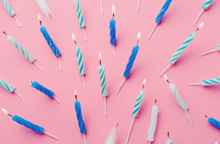 blue and white birthday candles over pink background.の素材