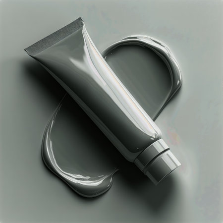 A grey cosmetic tube rests against a smooth surface with a dollop of matching cream beside it, creating a minimalist and modern aesthetic suitable for skincare promotion.の素材