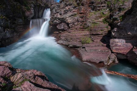 Saint Mary's Falls and Rainbow in Glacier National Parkの写真素材