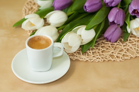 tulips on the table with cup of caffeeの写真素材