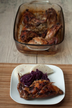 rabbit meat roaster with onion cumin and garlic on wooden vintage table with cabbage and dumplingの写真素材