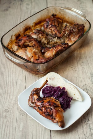 rabbit meat roaster with onion cumin and garlic on wooden vintage table with cabbage and dumplingの写真素材
