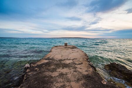 sunset on croatian stony beachの写真素材