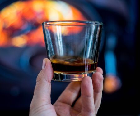 glass of rum before fireplace on mountainsの写真素材
