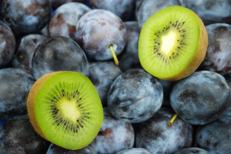 Close-ups of fresh plums and kiwi.の写真素材
