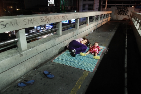 Homeless woman and a child sleeping in the street of Bangkok, Thailandのeditorial素材