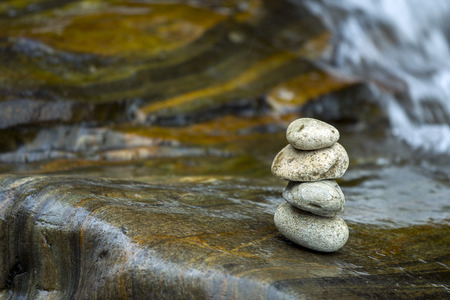 The arrangement of stone is back in the backdrop of a waterfallの写真素材