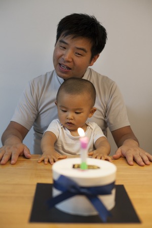 Chinese father and son celebrating son\'s one year old birthdayの写真素材