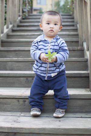 Cute Chinese baby boy playing outdoors, shot in Beijing, Chinaのeditorial素材