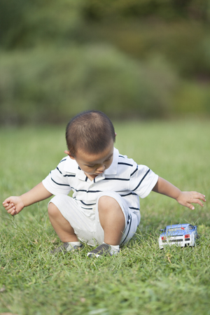 Happy Chinese baby boy playing a toy car, shot in Beijing, Chinaの写真素材
