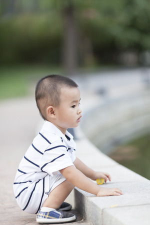 Happy Chinese baby boy playing in a park, shot in Beijing, Chinaの写真素材