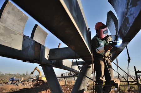 Welders welding pier