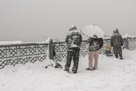 snow and people on galata bridge in istanbulの写真素材