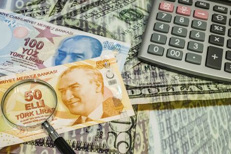 close up turkish lira banknotes with calculator and magnifier on backgroundの写真素材