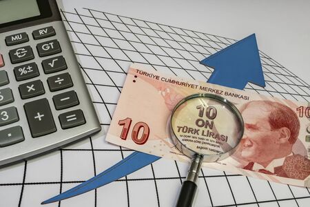 close up turkish lira banknotes with calculator and magnifier on background