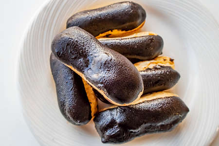 close up eclairs on white plate