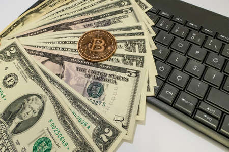 close up bitcoin coin with US dollars and computer keyboardの写真素材