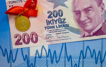 two hundred turkish lira paper banknote and turkish gold coin on background.の写真素材