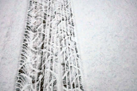 Snow and tire tracks on the road in winter