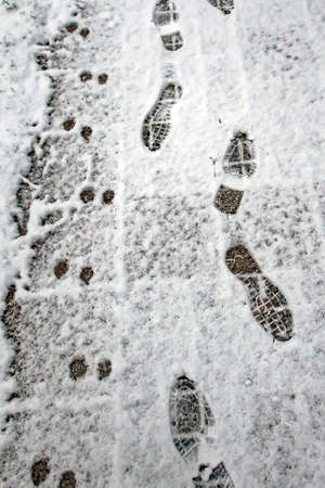 A snowy road and footprints in winterの写真素材