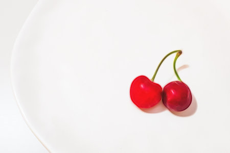 close up red cherries on white plate