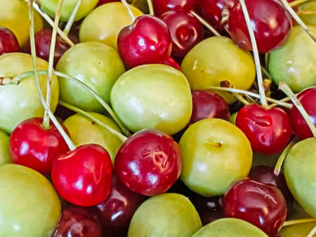 ready to eat and washed sour cherries and plums on a green plate with fruit figures