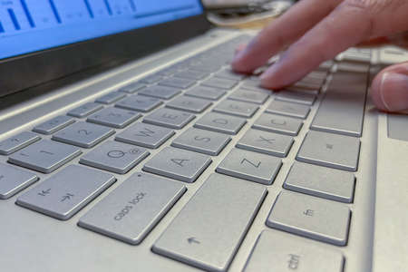Hand and keyboard of person using laptop for business and finance world.の写真素材