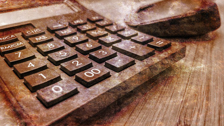 calculator on a wooden table with a blurred background, old photo effectの写真素材