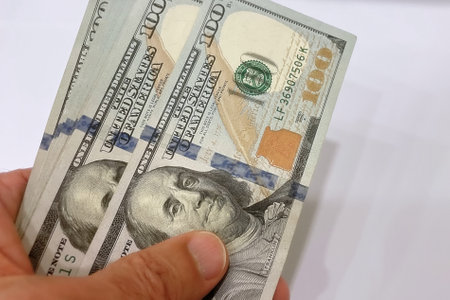 Hundred dollar bills in hand on white background. close up