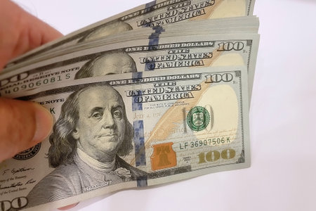 Hundred dollar bills in hand on white background. close up