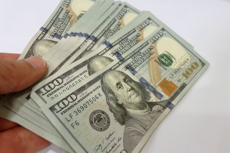 Hundred dollar bills in hand on a white background close-upの写真素材
