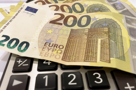 Calculator and Euro Bills.A professional stock photo of 200 euro banknotes on a calculator, ideal for financial and business concepts.の写真素材