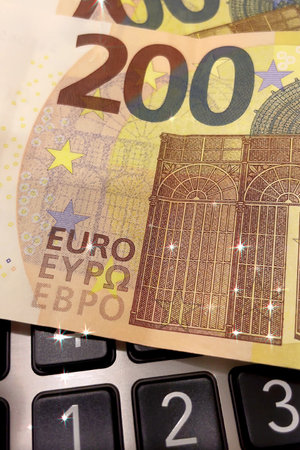 Calculator and Euro Bills.A professional stock photo of 200 euro banknotes on a calculator, ideal for financial and business concepts.の写真素材