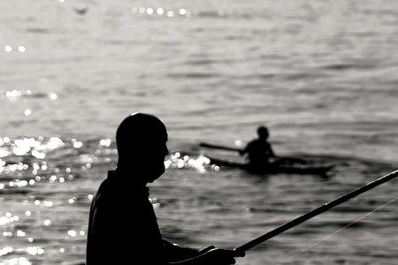 Silhouette of fisherman on the sea. Black and white.の写真素材