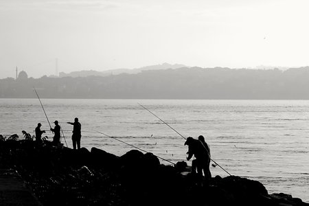 Silhouette of fishermen on the coast of Istanbul, Turkey.の写真素材
