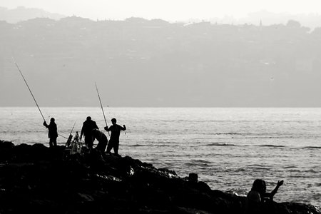 Fishermen at the coast of Istanbul, Turkey. Black and white photo.の写真素材