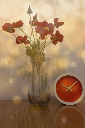 Red poppies in vase with clock on bokeh background