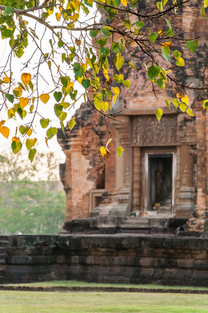 Blurred Sikhoraphum Khmer Ruin with Bodhi leaf in the foregroundの写真素材