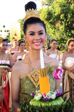 A cheerful woman with tradional clothing is holding Kratong in Loykratong festival Thailand.の素材