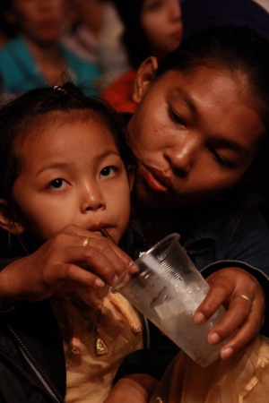 Asian mother feeding drinking water her doughter.の素材