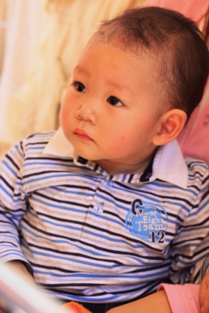 Asian baby boy in mother'arms looking forward.の素材