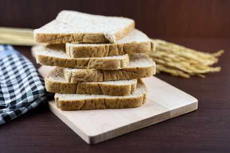 Sliced Whole wheat bread on Chopping Wood and tablecloth background, selective focus.の写真素材