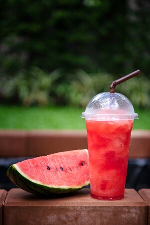 Watermelon smoothie with fresh watermelon slices on garden background.の写真素材