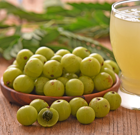 Indian gooseberry  in wooden bowl on a wooden floor.の写真素材